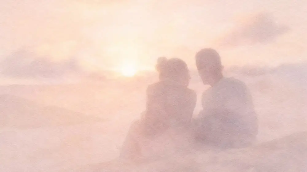 夕暮れの中で並んで座る人物のシルエット。孤独と人とのつながりを象徴するイメージ。