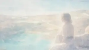 静かな風景を前に、一人で遠くを見つめる人物のシルエット